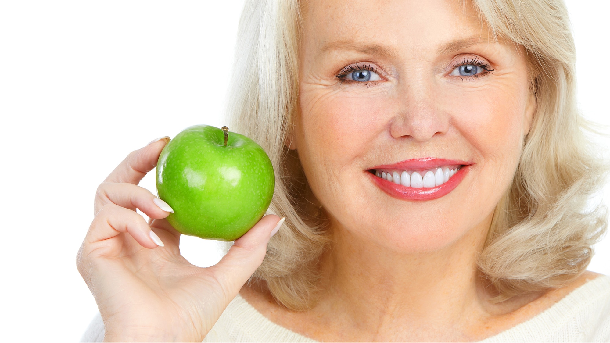 Elderly woman holding a ripe green apple. Are your cataracts ripe?
